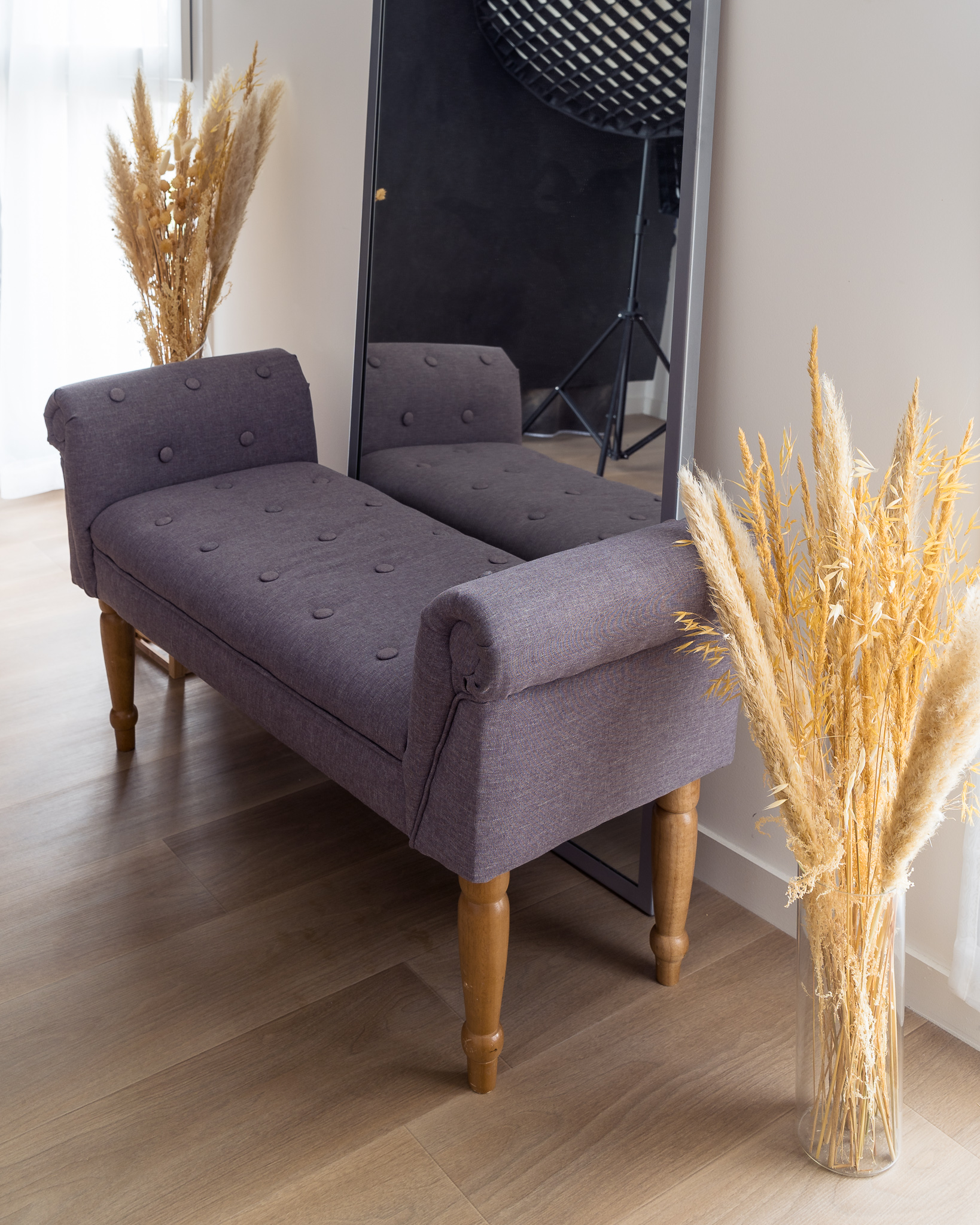 Le studio photo à Nantes contient une banquette, un miroir et des fleurs séchées.