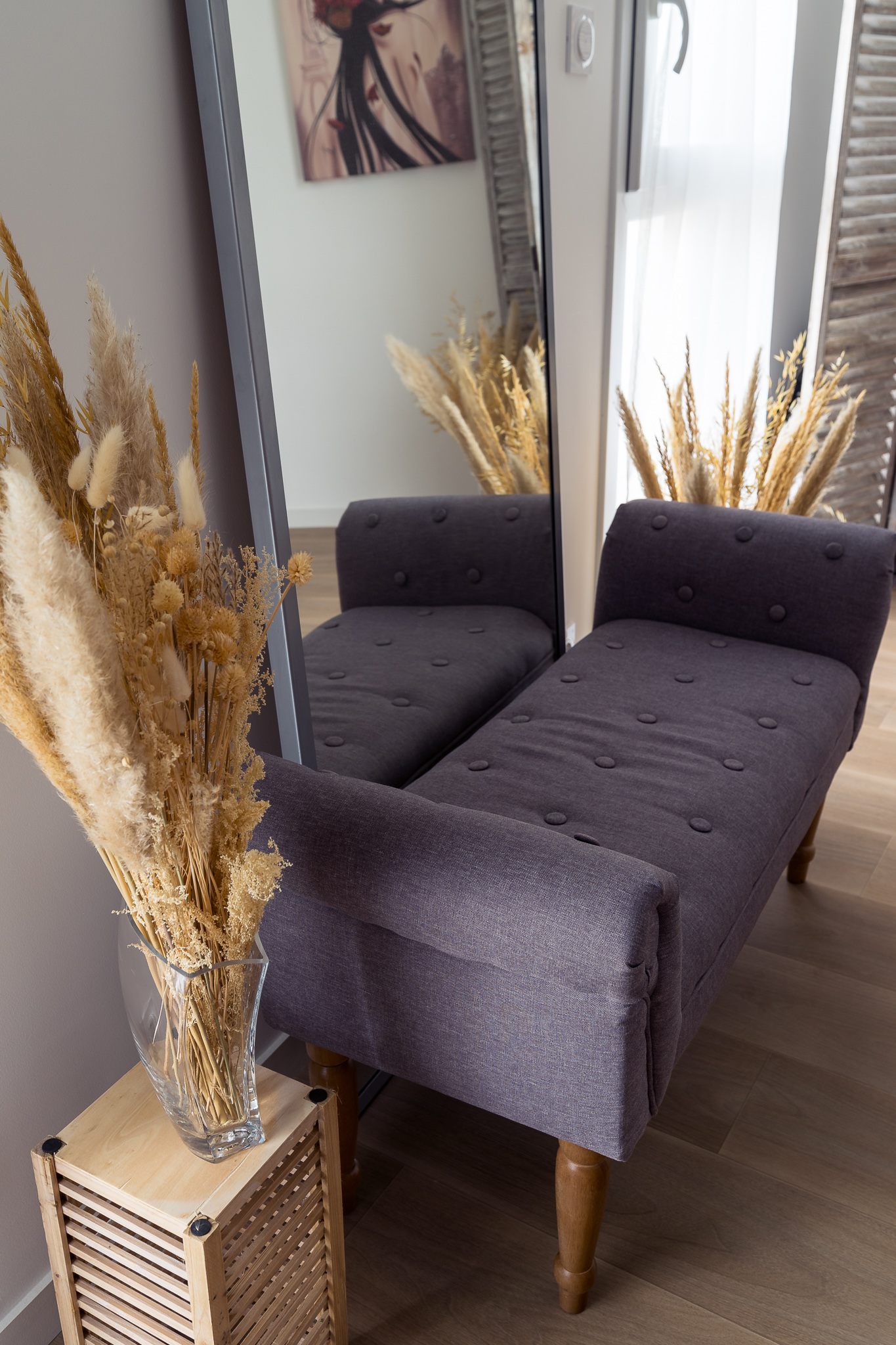 Le studio photo à Nantes contient une banquette, un miroir et des fleurs séchées.