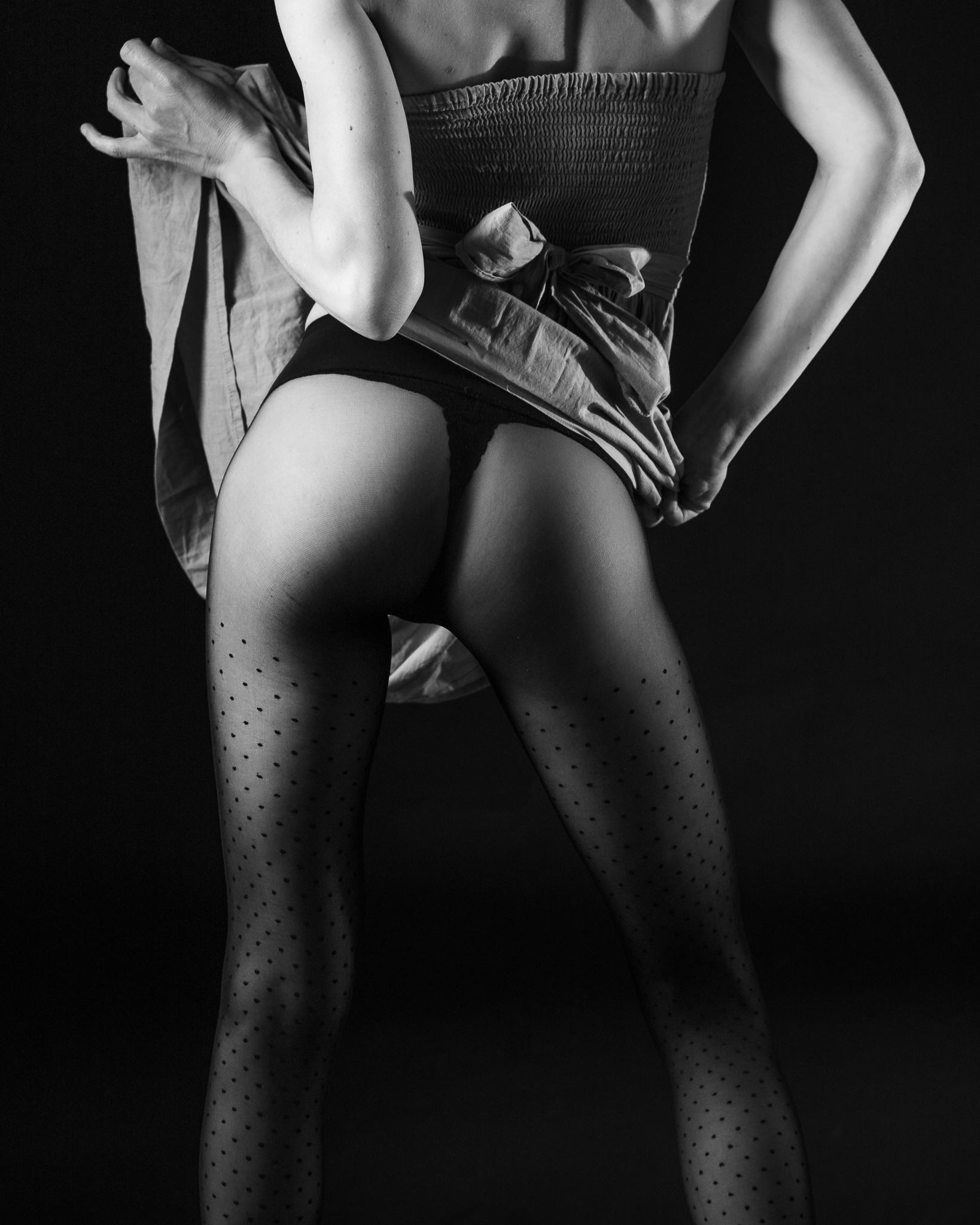 Séance photo boudoir pour mettre en avant jambes et collants. En noir et blanc.